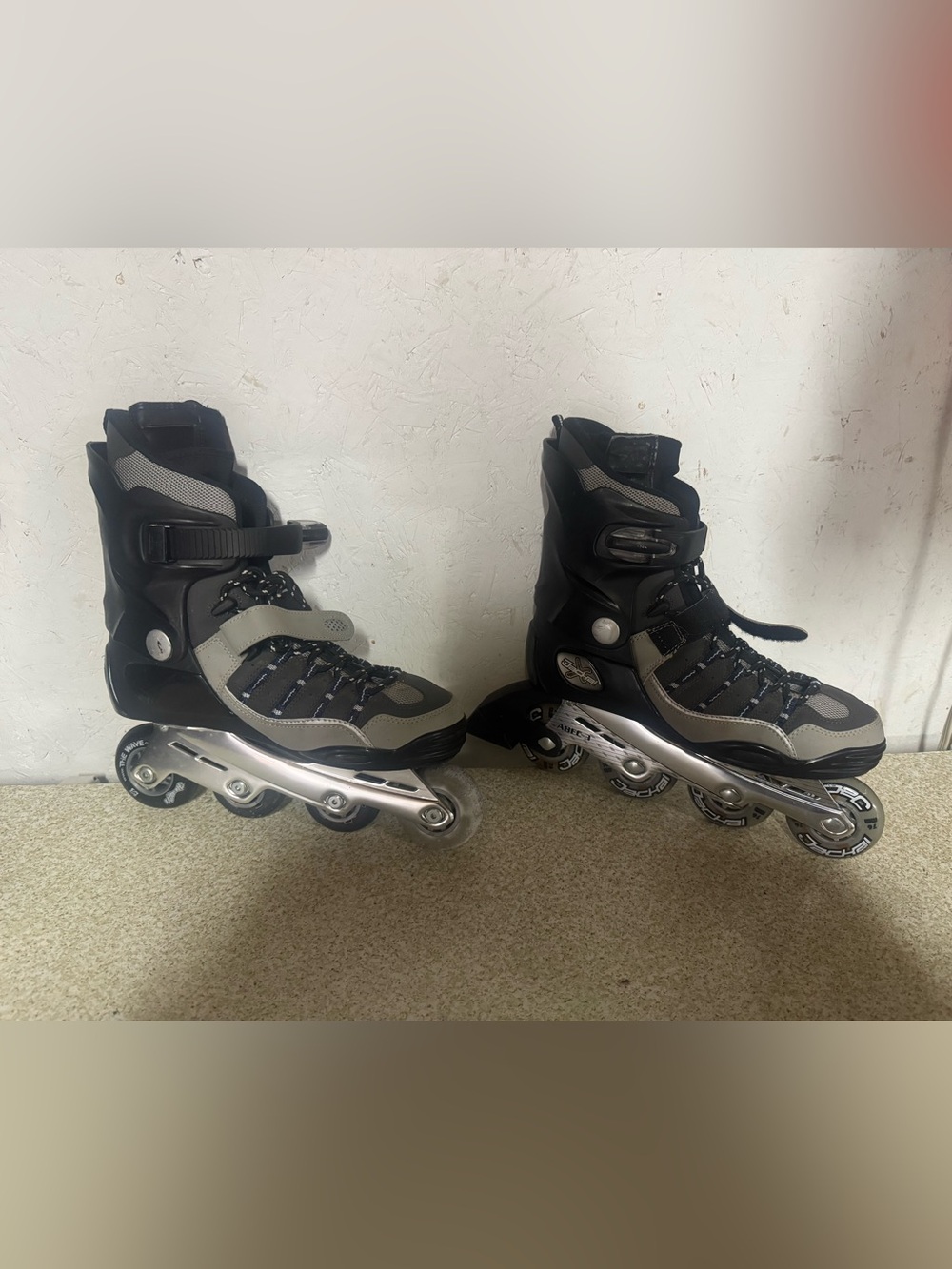 Men's Black and Gray Inline Rollerblades and a set of wrist guards